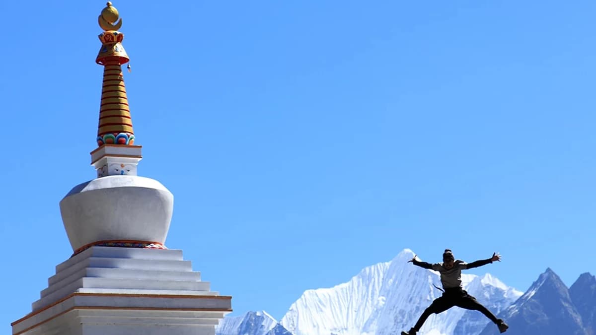 Langtang Valley Trekker with Snowy peak in background and Gumba on side